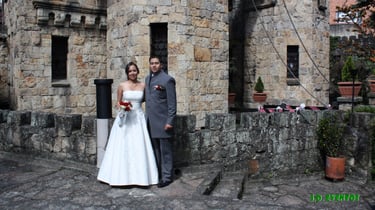 a bride and groom standing in front of a castle