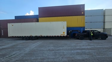 A black Ram 3500 pulling a 40ft trailer with a new 40ft tan chipping container
