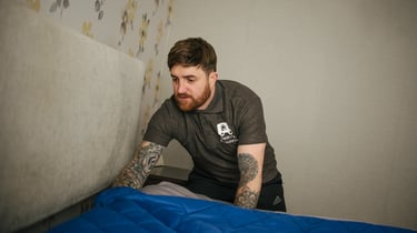 deano removals man covering a bed during a removals job in the city of worcester