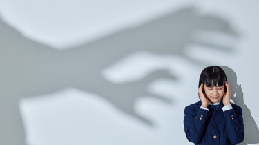 a woman in a blue suit and a hand holding her hands up to her face