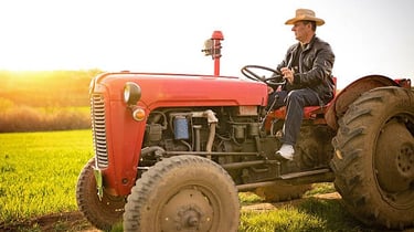 a man in a cowboy hat sitting on a tractor