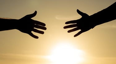 Helping hands reaching to one another