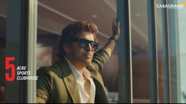 Actor Chiyaan Vikram looking out from a luxury balcony for a Casagrand real estate advertisement.