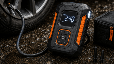 Portable digital tire inflator with LED display connected to a car wheel on wet pavement.