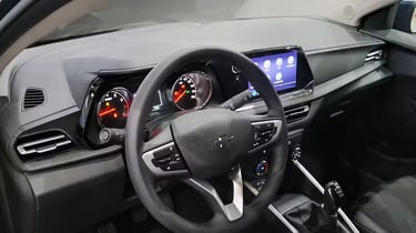 Interior view of a modern Chevrolet dashboard featuring a digital infotainment screen and manual gear shifter.