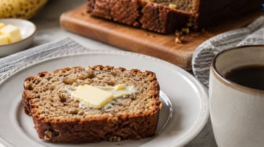 Slice of healthy banana bread topped with butter and coffee.