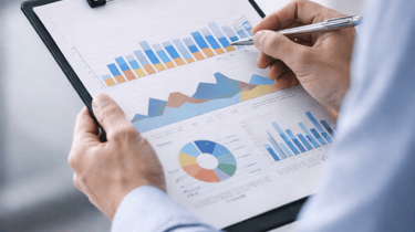 Advisor reviewing operational data and workflow signals on a clipboard to ensure sustained results and ongoing alignment.