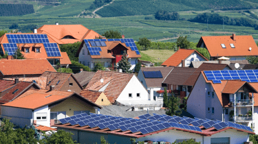 a group of houses with solar panels on the roof in gujarat