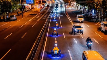 Street go-karts driving side by side on a city road at night in Japan