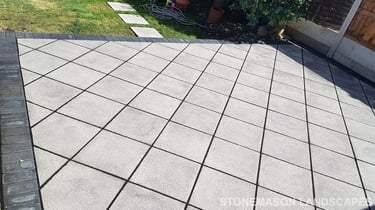 Basic grey patio with black charcoal edging blocks slabs laid in diamond format