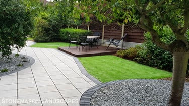 Patio with custom stone circle with aggregates and paving weaving through adventurous garden design