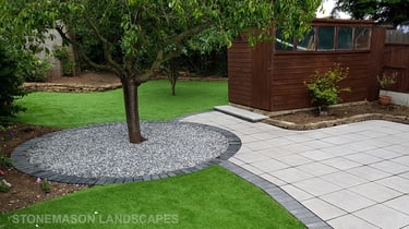 Patio with custom stone circle with aggregates and paving weaving through adventurous garden design