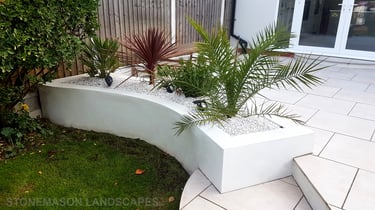 Modern chic raised porcelain patio with white rendered walls and planters