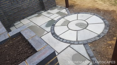 Grey sandstone circle paving slabs with charcoal edging
