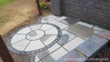 Grey sandstone circle paving slabs with charcoal edging