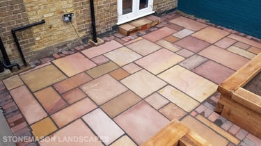 Colourful sandstone patio with raised wooden timber planter seating