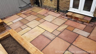Colourful sandstone patio with raised wooden timber planter seating