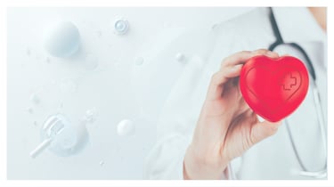 A doctor holding a red medical heart symbol representing cardiology care and healthcare services.