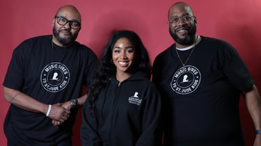 Three people smiling in black Music Gives to St. Jude Kids apparel against a red background.