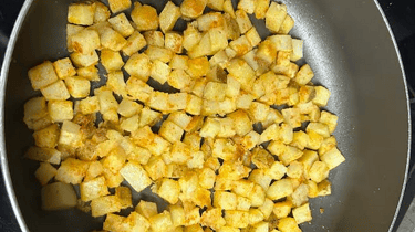 Breakfast Potatoes cooking in a pan on stove