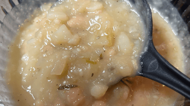 Potato Soup, when copleted, with large serving spoon starting to lift out of dish. For FlavorfulBites