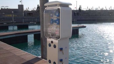 Colonnina elettrica marino bianco e stazione idrica situati su un molo in per barche in un porto