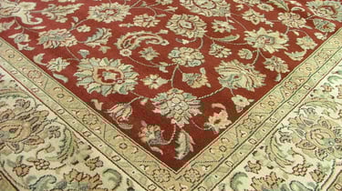Close-up of a traditional Persian-style area rug featuring intricate floral and paisley patterns in 