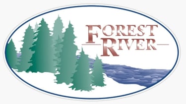 Forest River RV brand logo featuring green pine trees and a blue river in an oval frame.