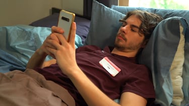 a man laying on a bed with a name tag on it