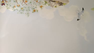 Hand-painted possum peeking from tree branches with clouds and flying gull — detail from Australian nursery mural