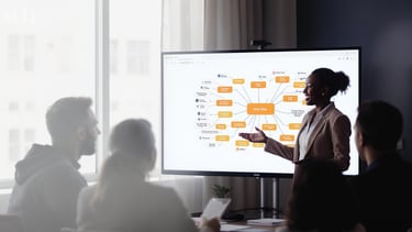 a woman in a business suit is standing in front of a large screen