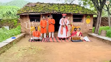 Folk artists dressed in colorful attire before a dance show at Shilpgram craft village.