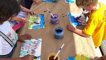 children applying watercolor wash to a drawing