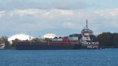 Tugboat Albert pushes barge Margaret past and industrial site.