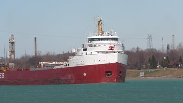 Classic red and white forward pilothouse freighter Frontenac approaching.