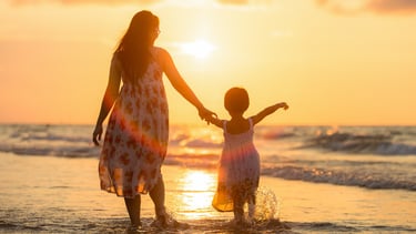 mother running with daughter on the beach
