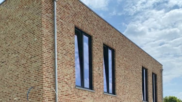 een bakstenen gebouw met blauwe lucht als achtergrond