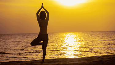 a person doing yoga on the beach