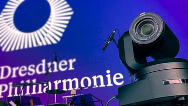 Professionelle Videokamera auf Bühne mit Giesinger Harmonie-Logo.
