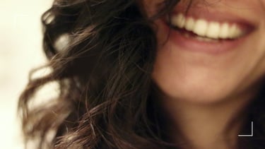 a woman with long hair and a smile on her face