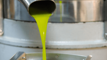 a yellow liquid pouring into a bucket of liquid