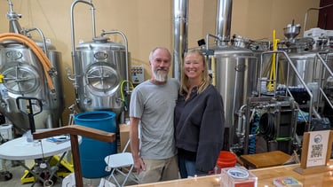 michael and kathleen cherry standing in front of brewing tanks