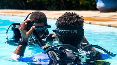 two people in scuba diving suits in a pool