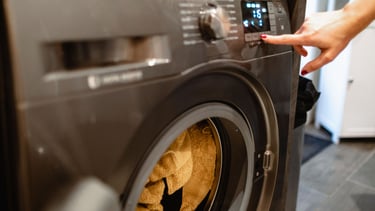 a person is putting a towel in a washing machine