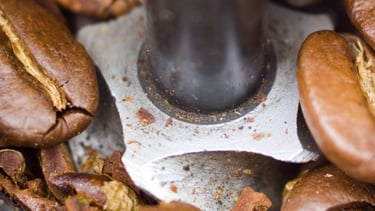 a spoon with coffee beans and coffee beans