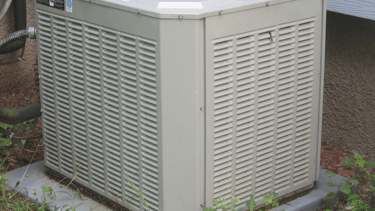 a small air conditioner sitting on a stone block