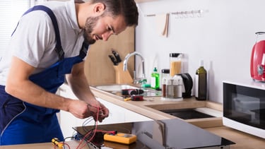 a man in a blue apron is working on a kitchen counter