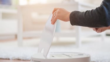 a person is putting a piece of paper in a box