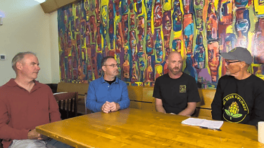 four men seated at a table at OBX Brewing Station