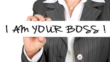 Führungskraft mit Schild „I am your boss“ – Symbol für Rollenwechsel im Führungstraining